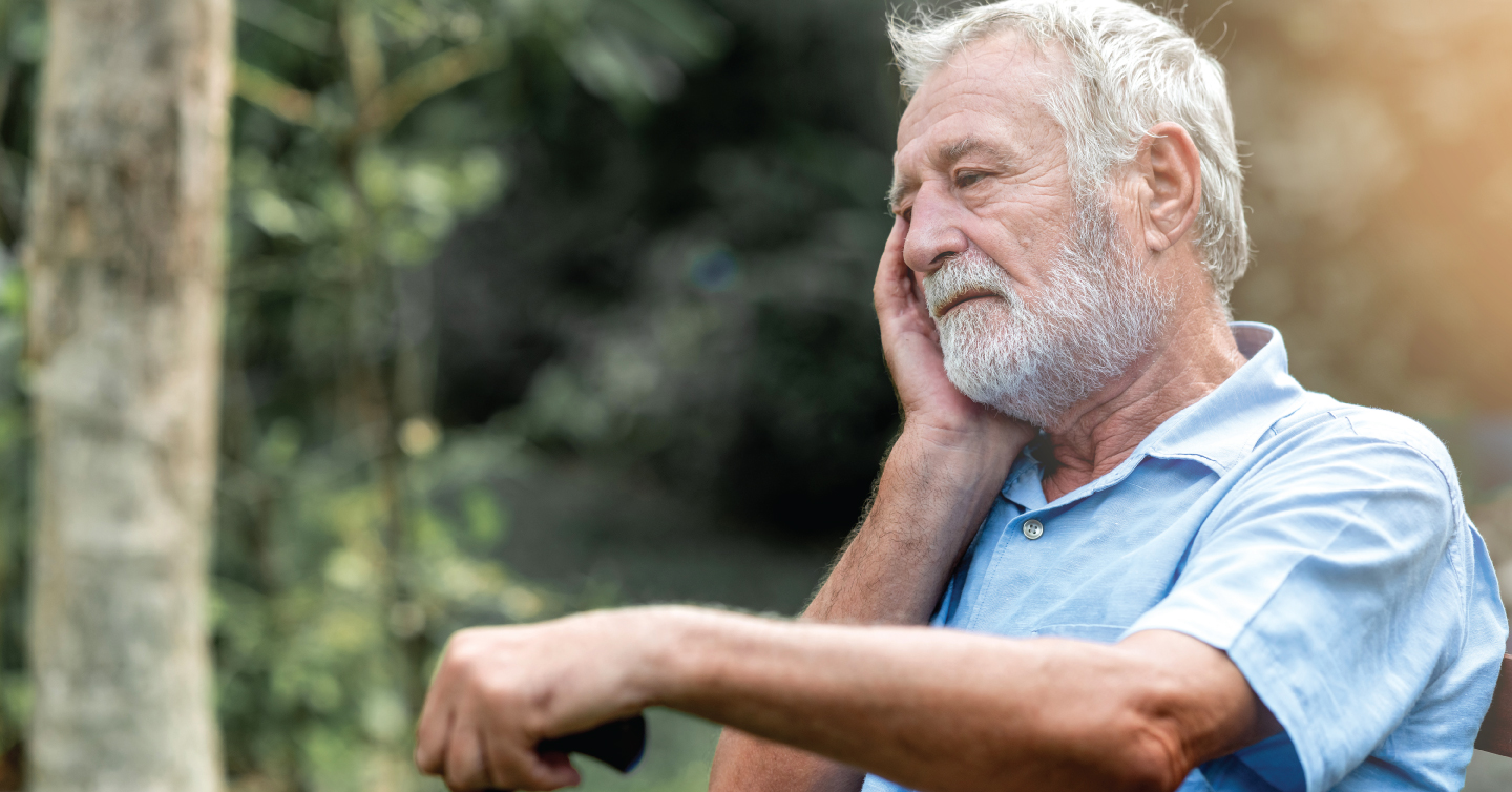an older man holding his ear