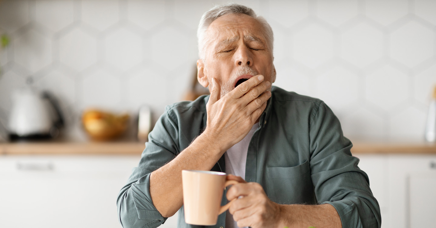 a man suffering from fall fatigue drinking coffee