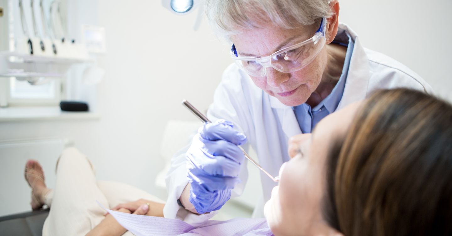 a dentist looking inside a patient's mouth