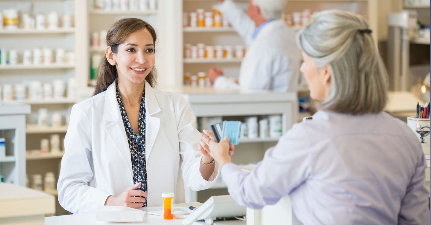a woman paying for medication at the pharmacy