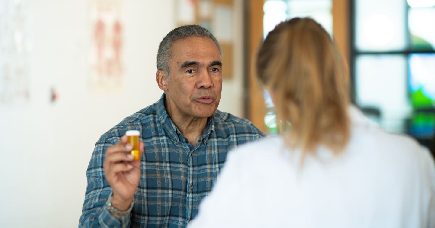 an older man talking to his doctor about osteoporosis medication