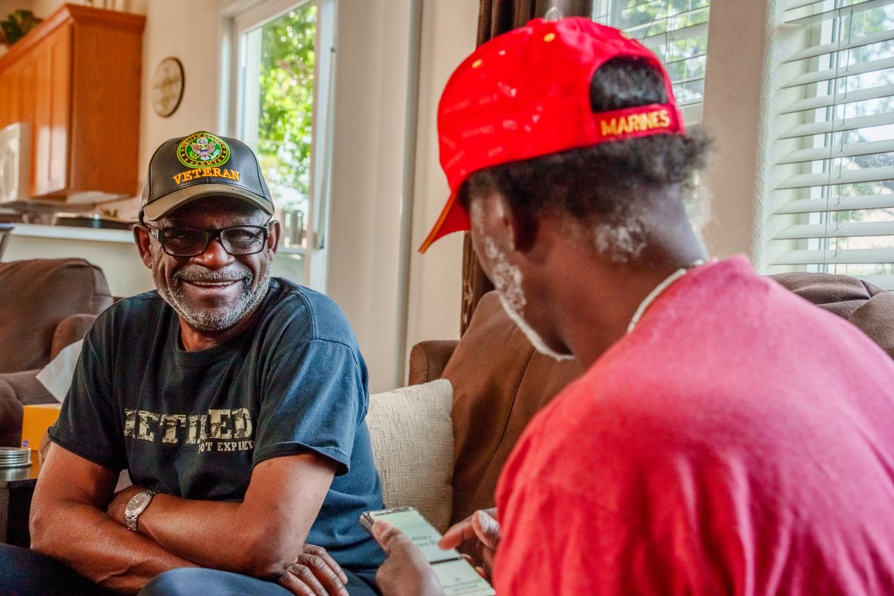 medicare-age military veterans talking in a home