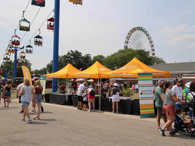 photograph of wisconsin state fair with network health tent centered and sky cars visible in upper end of photograph